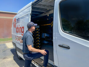 Plumbing service technician accessing tools and materials in plumbing truck
