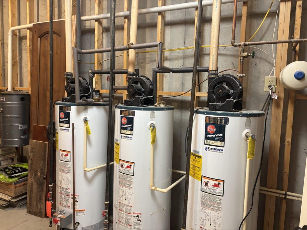 a water heater plumber is specifically trained to replace water heaters in a complicated set up like these three water heaters