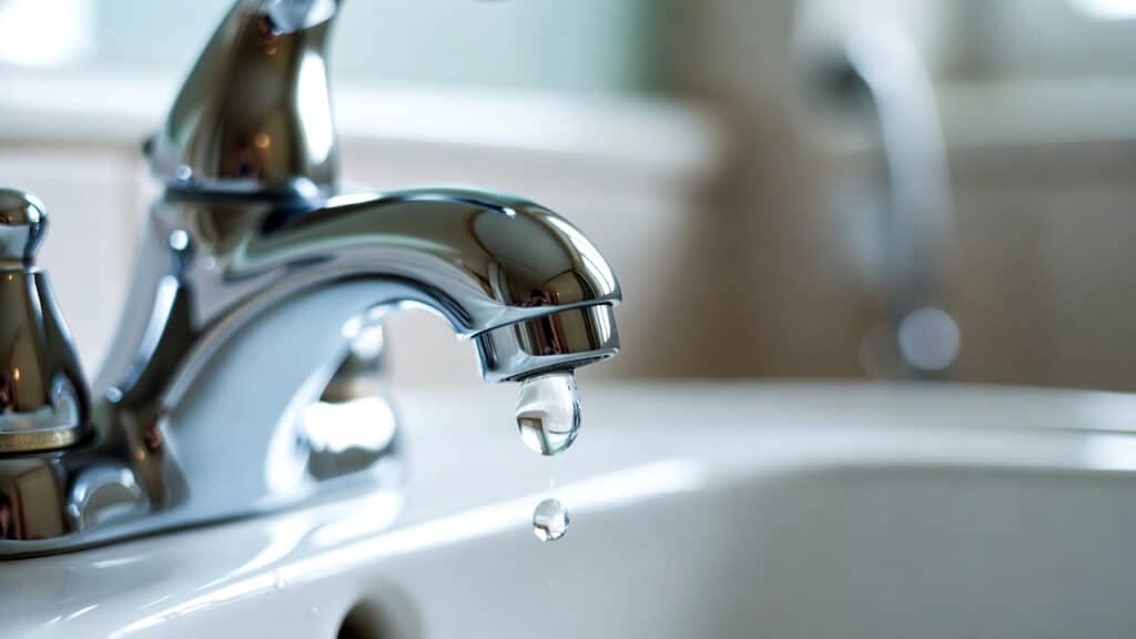 a chrome faucet dripping water in need of a bathroom sink repair