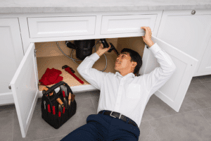 a plumber completing an inspection as part of a plumbing and hvac maintenance plan