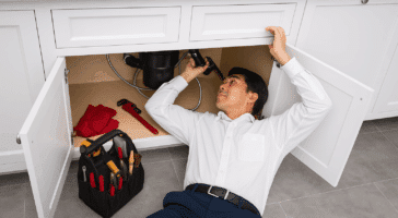 a plumber completing an inspection as part of a plumbing and hvac maintenance plan