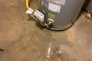 a water heater leaking from the bottom floods an unfinished basement