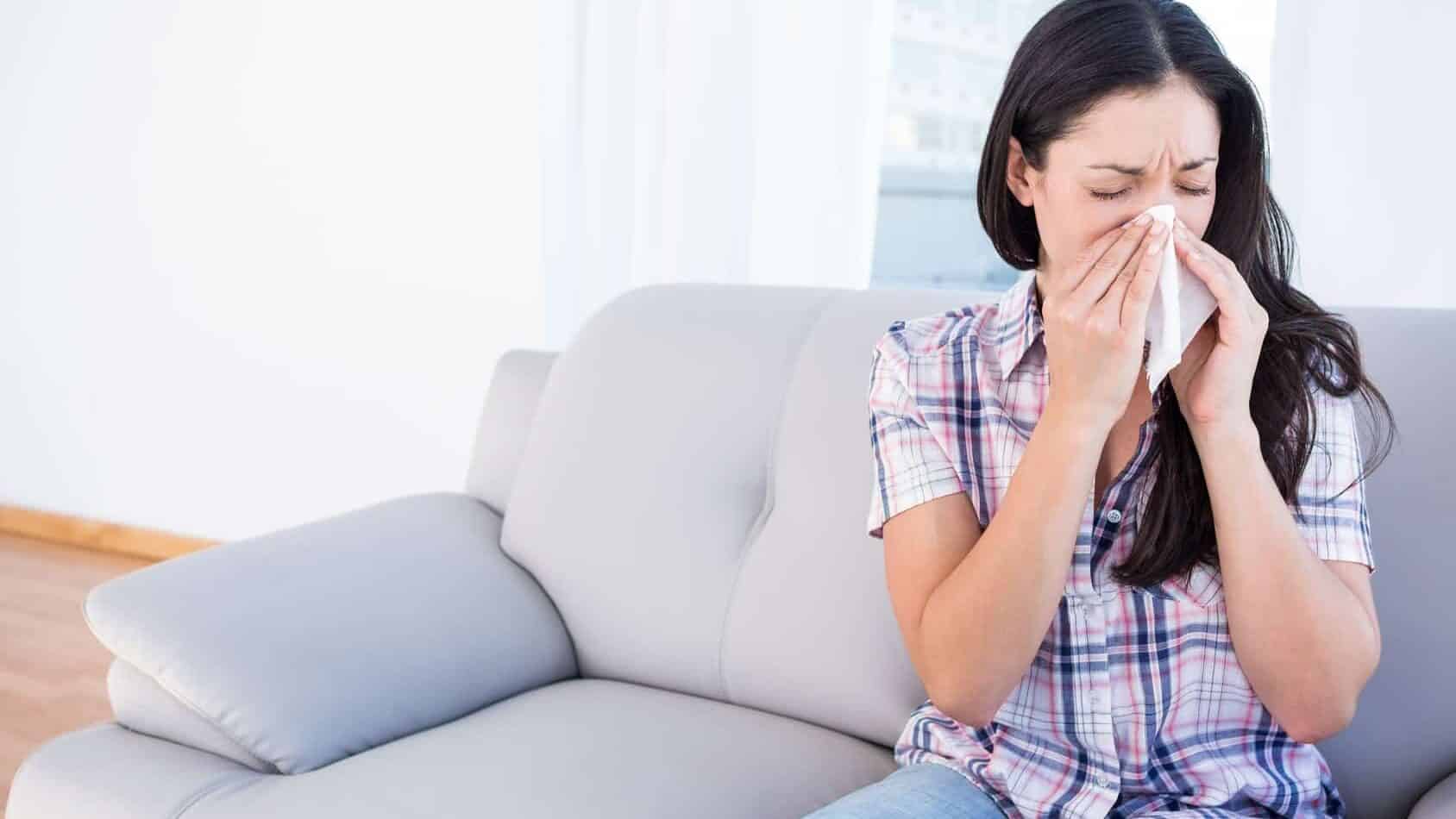 Woman sneezing due to allergens in the home and poor indoor air quality