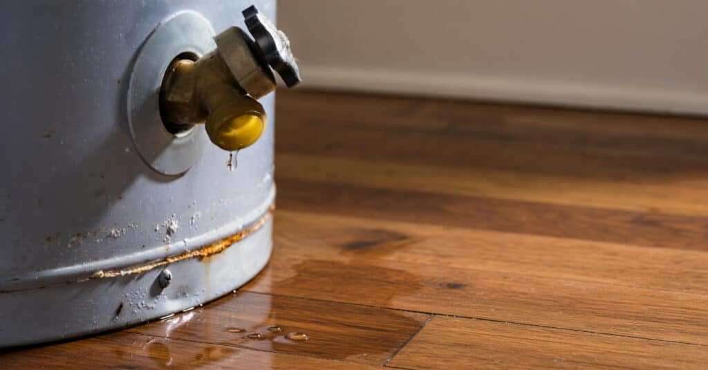 water heater leak on wood floor indicates water heater replacement needed