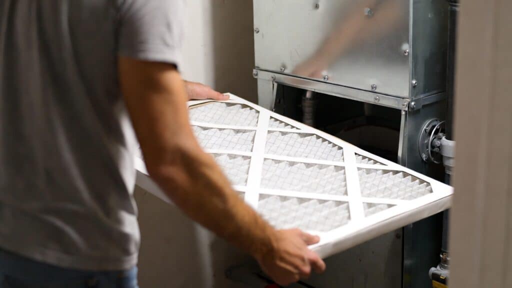 a homeowner changes his filter as part of ac troubleshooting process