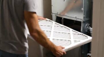 a homeowner changes his filter as part of ac troubleshooting process