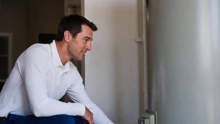 A plumber investigates a water heater to answer a customer's question of why is my water not getting hot?
