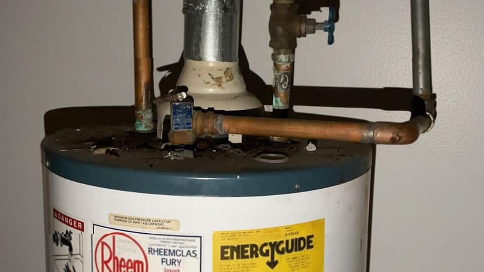 an old water heater leaking from the top