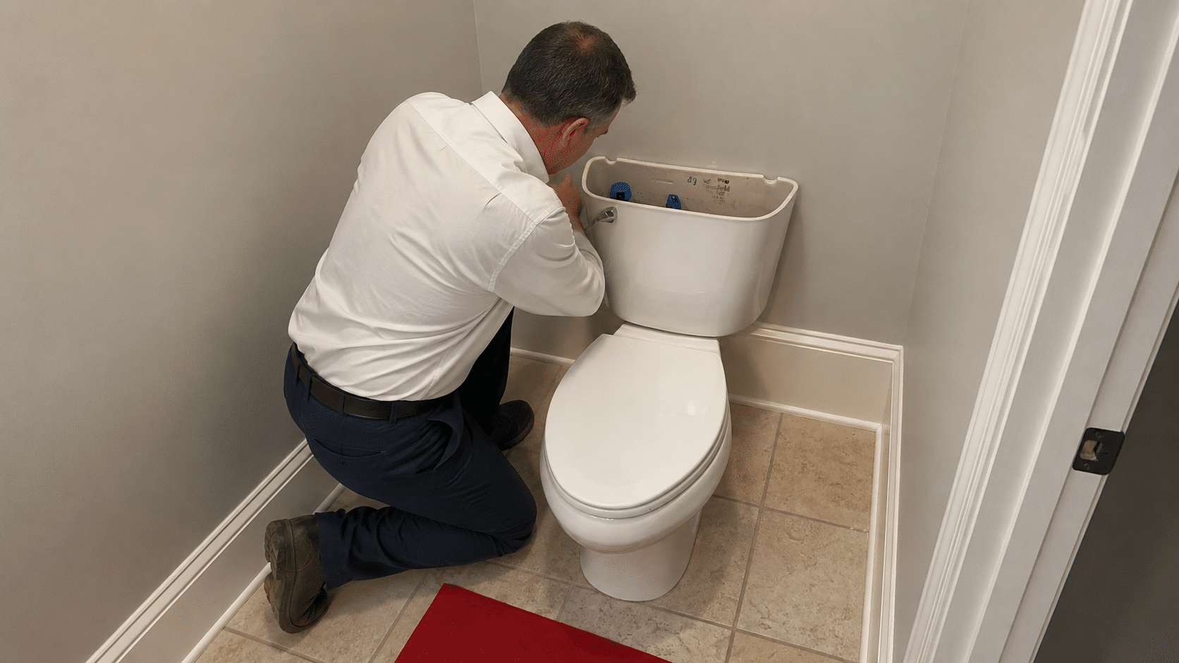 Plumber making repair to toilet in Buford