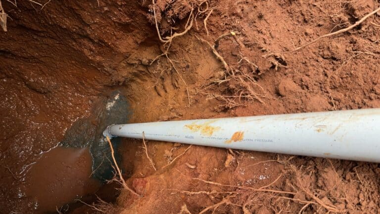 sewer line repair in Lawrenceville with exposed pipe in excavation trench