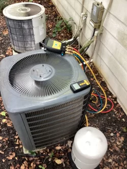 HVAC technician servicing outdoor AC unit with gauges and tools