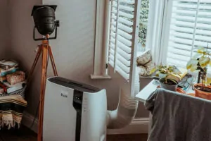 Portable air conditioner vented through window in cozy room
